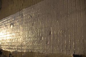 Light on wall. Wall tiles. Glint on building. photo