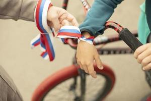 Ribbon of flag of Russia on hand. Tying symbol of state on wrist. Child with ribbon of three colors. photo