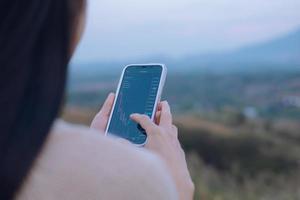 Woman is checking Bitcoin price chart on digital exchange on smartphone, cryptocurrency future price action prediction. photo