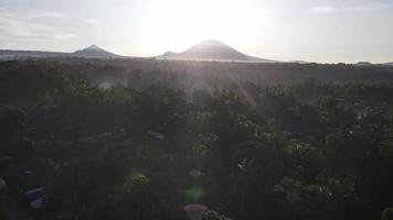 Sunrise over hillside with long sun rays pass through valley in village Bali, Indonesia video