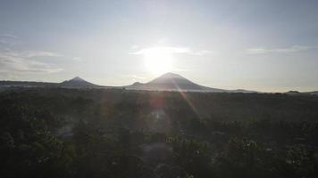 Sunrise over hillside with long sun rays pass through valley in village Bali, Indonesia video