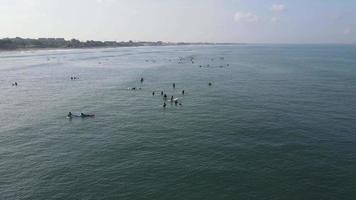 Aerial view of people surfing on waves with surfboards when vacation in Bali, Indonesia . video