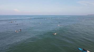 Aerial view of people surfing on waves with surfboards when vacation in Bali, Indonesia . video