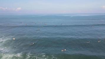 Aerial view of people surfing on waves with surfboards when vacation in Bali, Indonesia . video