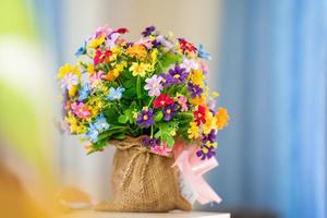 plastic flower In a rope basket, on a desk, in the house photo