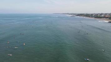 aereo Visualizza di persone fare surf su onde con tavole da surf quando vacanza nel Bali, Indonesia . video