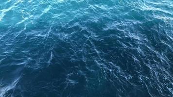 kalmte blauw zee golven met zonsondergang licht achter de schip. video
