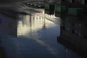 Puddle in road. Wet asphalt. Spring weather. photo