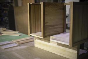 Creation of furniture in carpentry workshop. Table made of wood. Polished board. Project of cabinet for things. photo