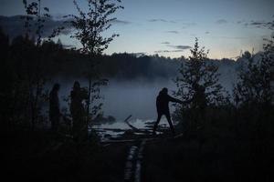 Man in fog on lake. Early morning in woods. photo