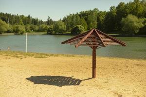 Beach in city. Umbrella on beach. Sand and lake. photo