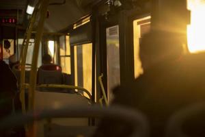 Inside bus is light of sun. People in transport. photo