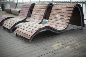 Benches for recreation in park. Comfortable seating. Sun beds on waterfront. photo