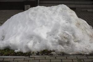 Parting snow on road. Puddle in city. photo