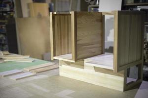 Creation of furniture in carpentry workshop. Table made of wood. Polished board. Project of cabinet for things. photo