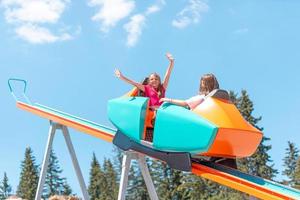 Girls are riding a mountain coaster with outstretched arms photo