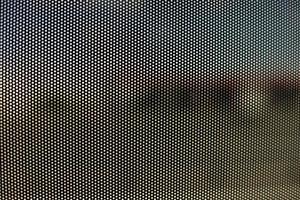 Mesh texture on glass. Shooting window. Small cage. photo