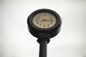 Post clock. Glittering clock against sky. Dial is outside. photo