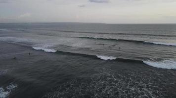 antenn se av människor surfing på vågor under solnedgång när semester i bali, Indonesien. video