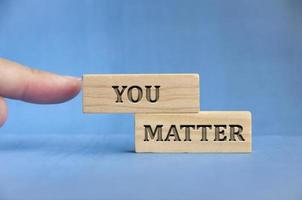 Finger pointing you matter text engraved on wooden block. Inspirational concept photo