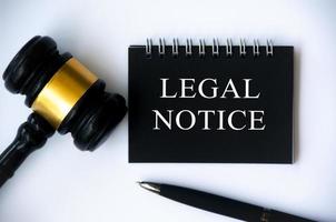 Legal notice text on black notepad with gavel and pen on white background. legal and law concept photo