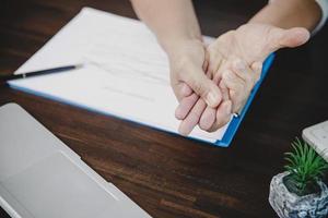 Arthritis person, finger woman ache from working in office. Concept office syndrome hand pain from occupational disease, woman having wrist pain from using laptop computer, wrist pain. photo