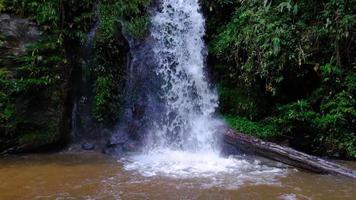 Waterfall slow motion footage, flowing water stream in a tropical rainforest in Thailand.