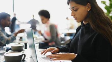 mujer en la cafetería trabaja y estudia en la computadora portátil video