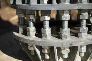 Nuts on bolts. Base of communication pole. Steel structural elements. photo