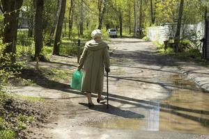 pensionista camina por la calle. abuela en rusia. mujer con bastón. foto