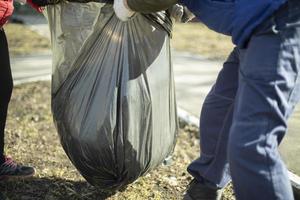 Harvesting leaves in bag. Putting things in order on street. photo