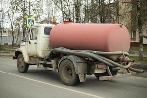 Car for pumping out sewers. Truck with tank. Old technique for pumping out feces. photo