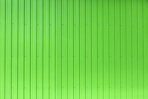 Green wall is made of metal. Texture of building. Bright surface. photo