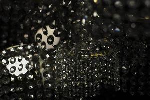 Texture of transparent glass in artificial light. Details of chandelier made of glass in dark. photo