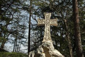 Christian cross made of stone. Details of temple. Ancient artifact. Details of sculpture. photo