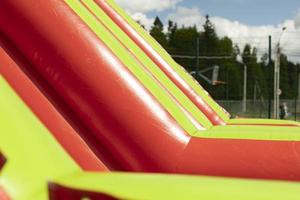 Inflatable slide of red color. Obstacle course in summer. Amusement park. photo