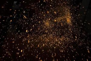 Sparks from saw. Lots of sparks in dark. Sawing steel. photo