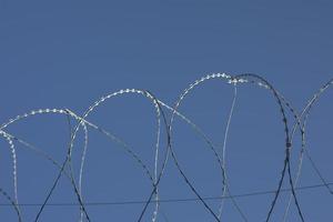 Barbed wire rings on fence. Protected area. photo