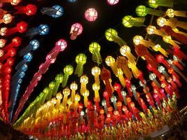 vista colorida hacia arriba y hacia abajo de las linternas de estilo lanna tailandés para colgar frente al templo en la noche en el festival de loy kratong. foto