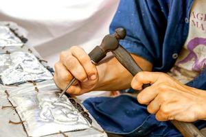 Closeup and crop Thailander Demonstration of Carved silver plate at Chiang Mai, Thailand. photo