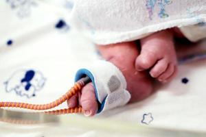 Sick newborn baby foot Insert a strap to measure oxygen in the blood and see the oxygen value for organs. photo