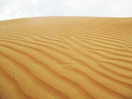 olas de textura de arena. dunas del desierto. paisaje de puesta de sol de dunas del desierto. foto