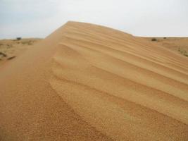 olas de textura de arena. dunas del desierto. paisaje de puesta de sol de dunas del desierto. foto