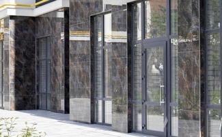 Facade of commercial premises with panoramic windows at street level in a new modern residential complex. Commercial real estate for rent in a typical building. photo