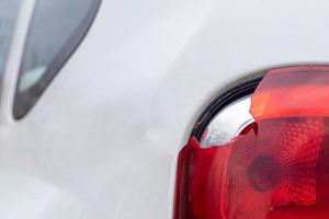 The rear left lamp of a white car is broken. The taillight of the car was shattered in the accident. Damage accident. Security concept. Rear stop of a car in an accident close-up. photo