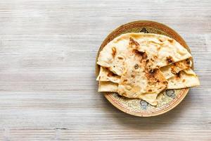 Naan flat bread baked in tandoor on brass plate photo