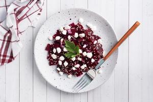 Salad of boiled beetroot and grain curd with sesame seeds on a plate. Copy space photo