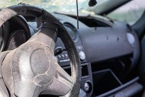 Close-up of the steering wheel of a car after an accident. The driver's airbags did not deploy. Soft focus. Broken windshield with steering wheel. Vehicle interior. Black dashboard and steering wheel. photo