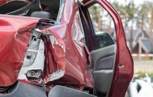 coche rojo después de un terrible accidente al costado de la carretera. impacto frontal y lateral. seguro de vida. un accidente sin posibilidad de recuperación. vista trasera. daño después de un accidente. foto