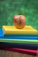 Apple fruit on top of a book stack, on the back of school classes. photo